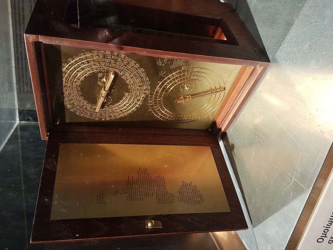 A modern reconstruction of the Antikythera mechanism in a wooden case with brass dials and pointers on its front face
